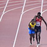 Jonathan Busby, completa los 5.000 metros ayudado por otro atleta jonathan