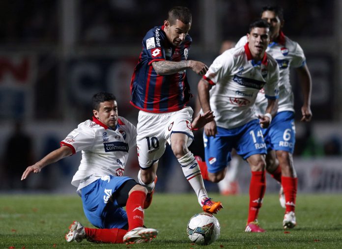 Leandro Romagnoli de San Lorenzo de Argentina es marcado por Julián Benítez de Nacional de Paraguay durante el partido de vuelta de la final de la Copa Libertadores de América en Buenos Aires