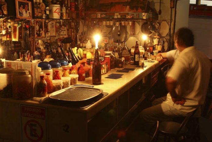 Clients drink and talk to candlelight during a blackout in Sao Paulo