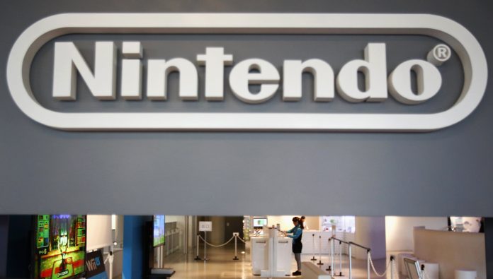 A staff of Nintendo Co Ltd showroom working is seen under its logo at its showroom in Tokyo