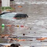 Tormentas e inundaciones dejan al menos 46 fallecidos en Alemania y Bélgica Una mujer trata de cruzar la calle con el agua al cuello en Lieja, Bélgica