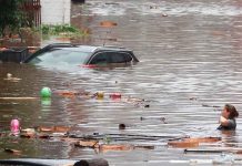 Una mujer trata de cruzar la calle con el agua al cuello en Lieja, Bélgica