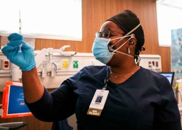 Enfermera con una vacuna lista para aplicar