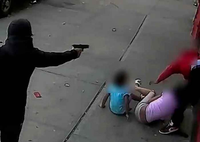 Hombre enmascarado dispara a un hombre con niños