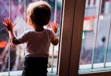 Menor de edad frente a una ventana