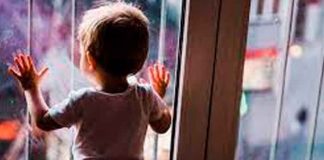 Menor de edad frente a una ventana