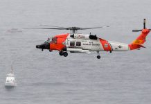 Un helicóptero de la Guardia Costera de EE. UU. Sobrevuela los barcos (Foto AP / Denis Poroy)