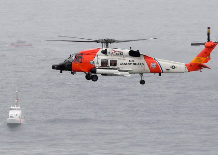 Un helicóptero de la Guardia Costera de EE. UU. Sobrevuela los barcos (Foto AP / Denis Poroy)