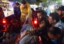 Voluntarios y personal médico trasladan a un herido para que reciba tratamiento tras dos potentes explosiones