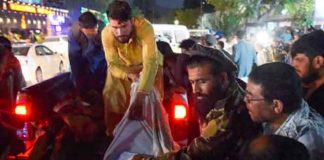 Voluntarios y personal médico trasladan a un herido para que reciba tratamiento tras dos potentes explosiones