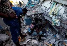 Personas en los escombros de un edificio tras el terremoto en Haití