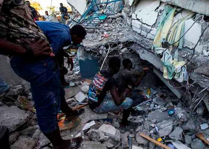 Personas en los escombros de un edificio tras el terremoto en Haití