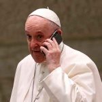 El papa Francisco habla por teléfono durante la audiencia general semanal en el Aula Pablo VI del Vaticano, el 11 de agosto de 2021. / FOTO / AP Photo / Riccardo De Luca