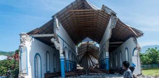 Un joven camina frente a una iglesia destruida por el potente sismo de 7,2 grados en Haití / FOTO / AFP