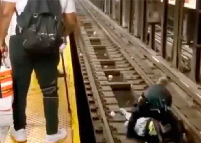 Momento en que un policía rescata al hombre de las vías del metro