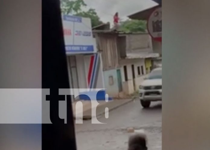 Una mujer fuera de sí se sostiene de unos cables de energía en Waslala