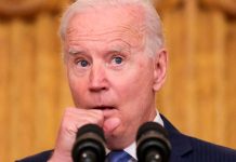 Joe Biden tose en su palma y continúa saludando de manos al público Joe Biden tose en su palma y continúa saludando de manos al público