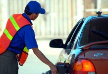 Comunicado del INE Y Ministerio de Energía y Minas Hombre trabajando en una gasolinera despachando combustible