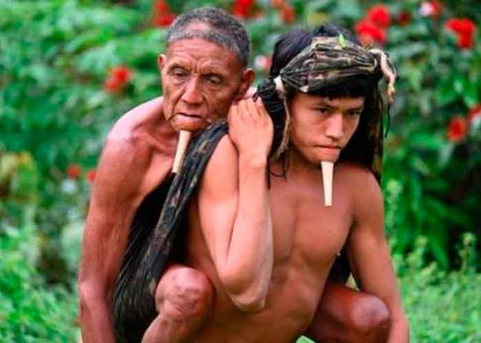 Joven carga a su padre para ser vacunado contra el COVID en Brasil