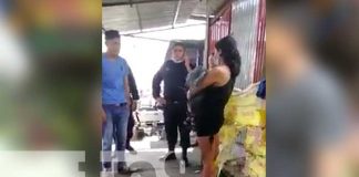 Mujer carga bebé muerto en una parada de buses en Managua