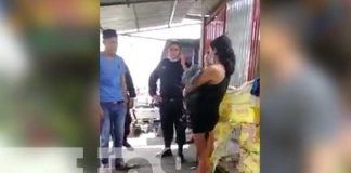Mujer carga bebé muerto en una parada de buses en Managua