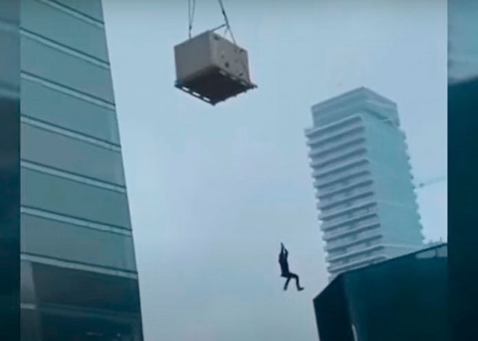 Obrero cuelga de una grúa de un edifico en construcción (Video)