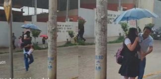 Padre carga a su hija para que su uniforme no se ensucie