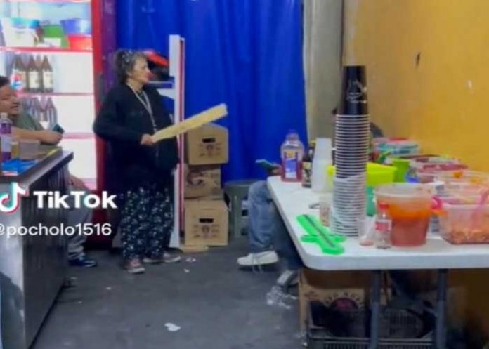 1 A garrotazo una madre saca a sus hijo de un puesto de licor.