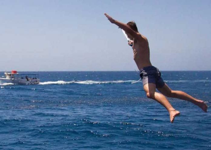 1 Todo por una apuesta de amigos: Joven se lanza a zona de tiburones (Video)