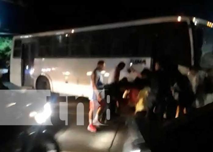 Motociclista y acompañante bajo las pesadas llantas de un bus en la entrada de Ciudad Sandino