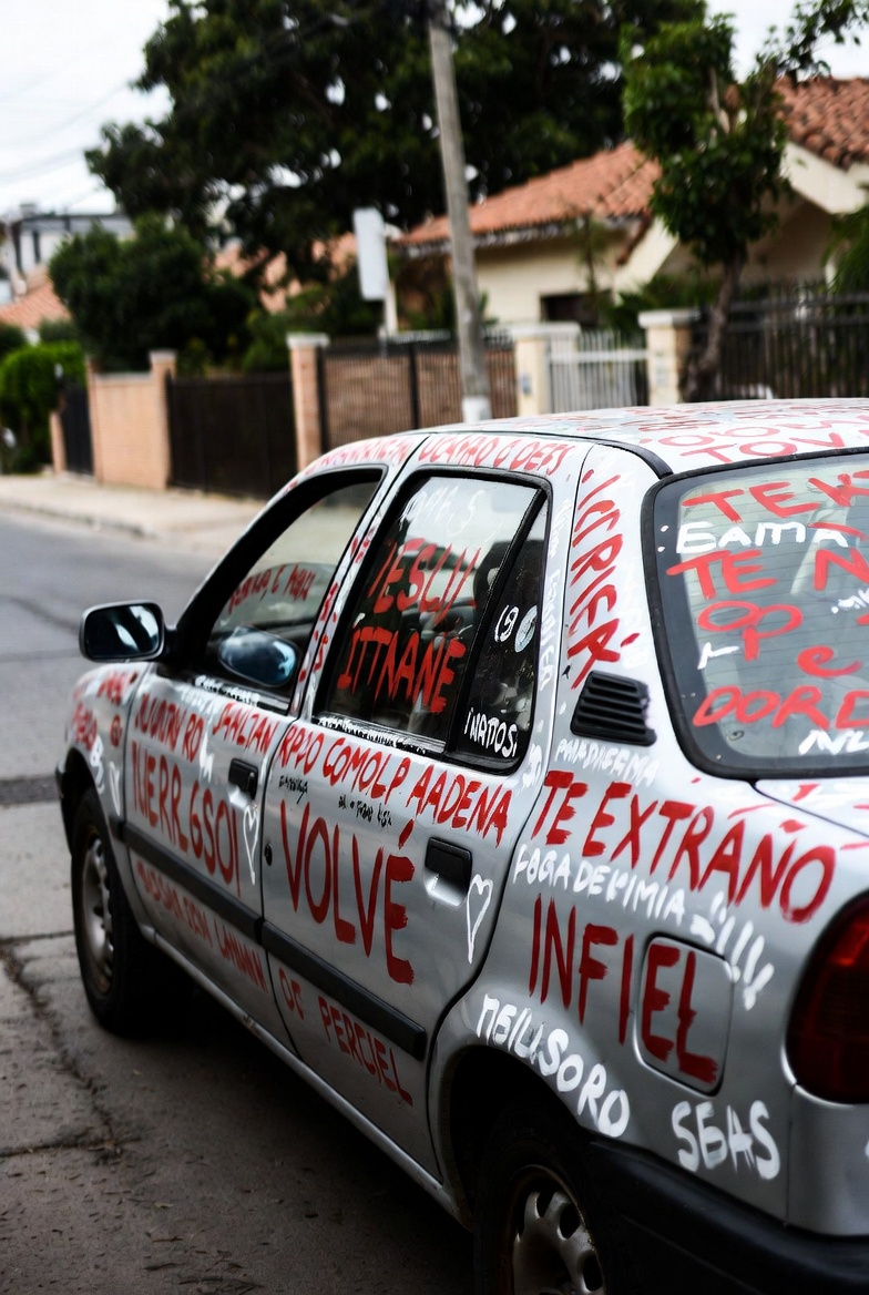 Foto: Un vehículo rayado con frases de desamor te extraño infiel 